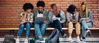 Multiracial group of high school students learning together at school